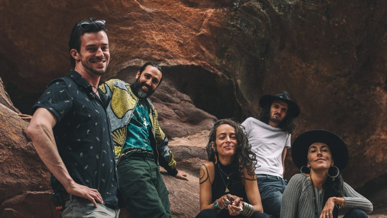 Rising Appalachia with their band, gathered among red sandstone rocks